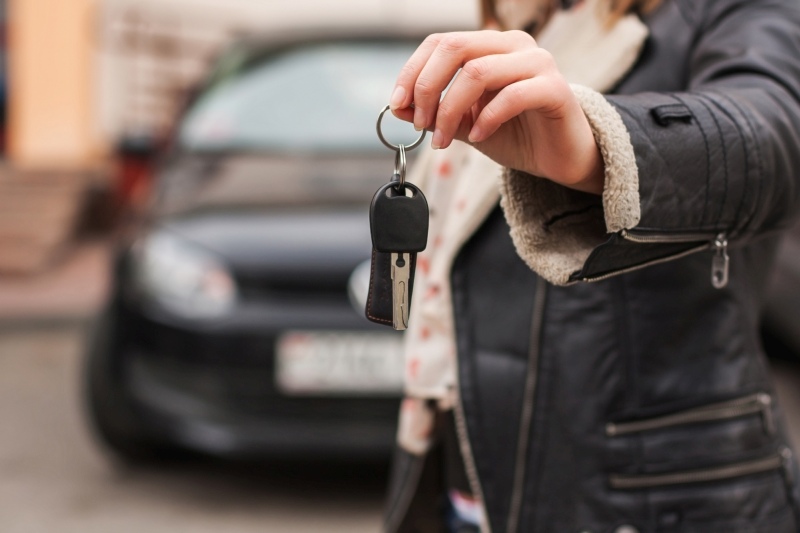 Frau übergibt Autoschlüssel