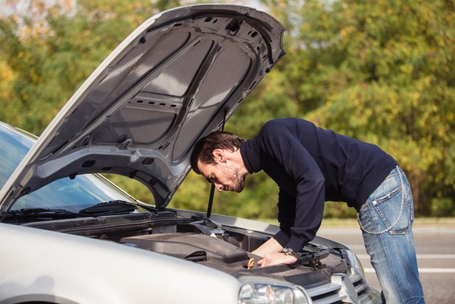 Mann am defekten Auto