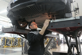 Kfz-Mechatroniker unter Auto