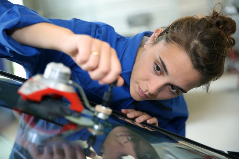 Frau beim Windschutzscheibe reparieren