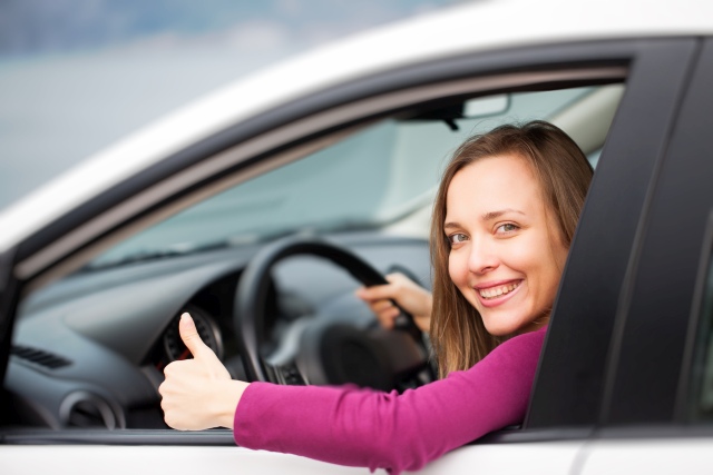 Frau im Auto mit Daumen hoch