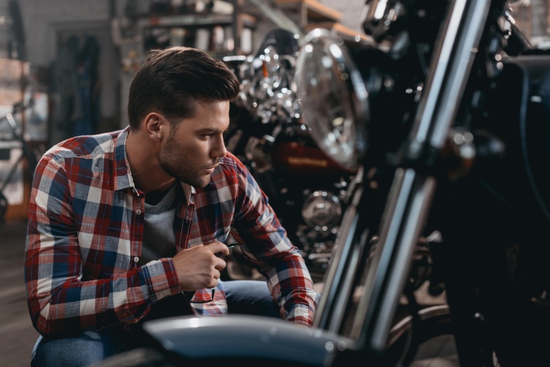 Motorradfahrere begutachtet sein Bike